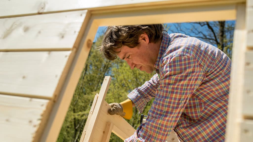 Mann baut Grillhütte